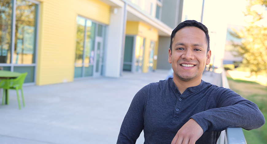 Andres Arias standing in front of campus building