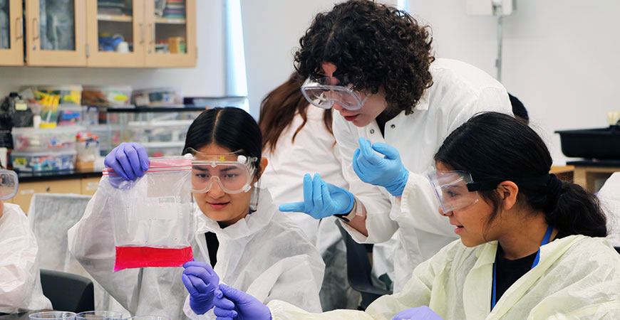 An undergraduate students works on a science experiment with two middle school students during a CalTeach Bobcat Summer STEM Academy camp.