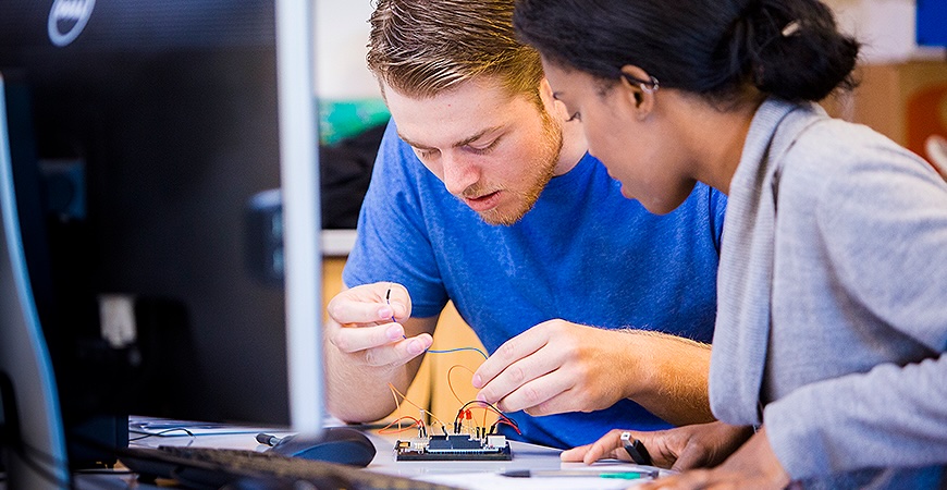 Photo depicts two students working on a circuit board at UC Merced.