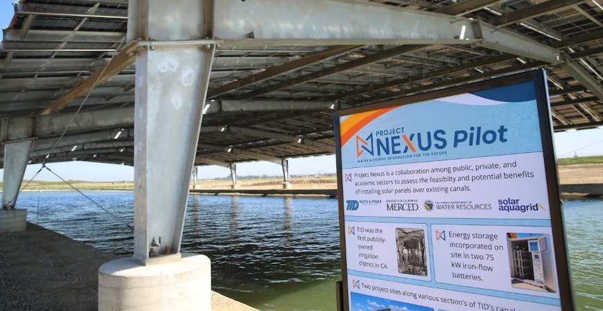 Depicted is a poster describing solar-over-canal Project Nexus in front of the actual structure.