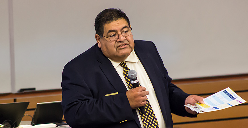 Man in business suits gestures while addressing a crowd