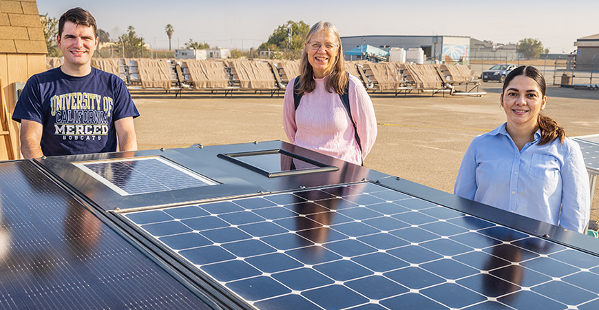 Professor Sarah Kurtz, center, poses with graduate students Aaron Wheeler and Dalia Martinez behind a solar panel.